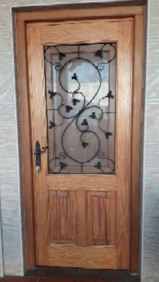Puerta madera exterior con reja castellana y post.