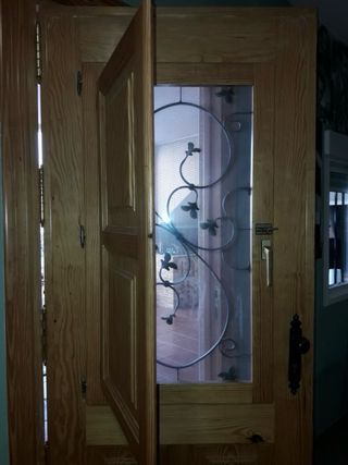 Puerta madera exterior con reja castellana y post.