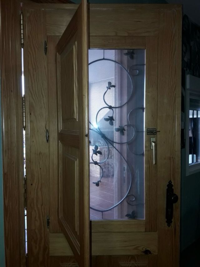 Puerta madera exterior con reja castellana y post.