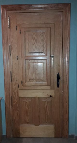 Puerta madera exterior con reja castellana y post.