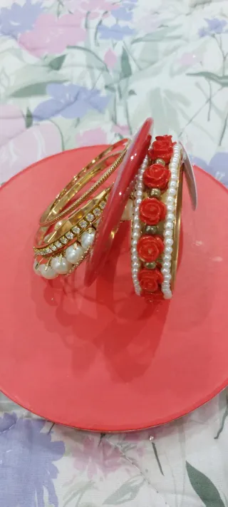 Set braccialetti dorati con perle e rose rosse