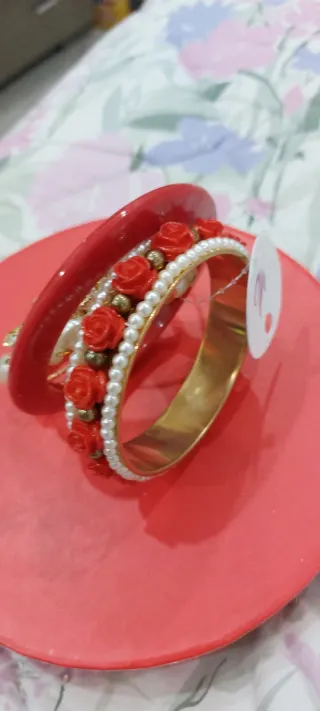 Set braccialetti dorati con perle e rose rosse