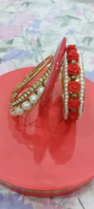 Set braccialetti dorati con perle e rose rosse