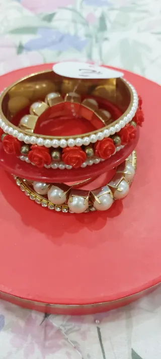 Set braccialetti dorati con perle e rose rosse