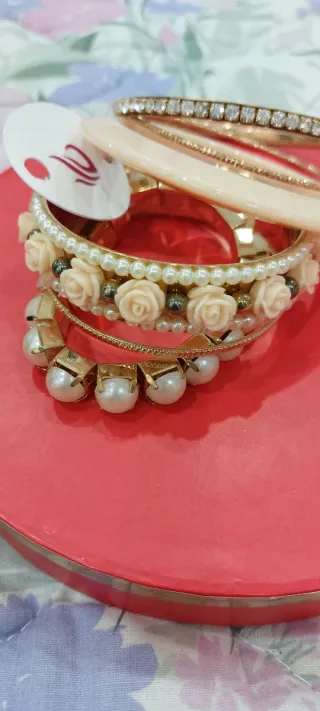 Set braccialetti dorati con perle e rose rosse