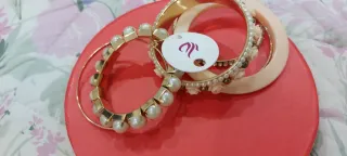 Set braccialetti dorati con perle e rose rosse