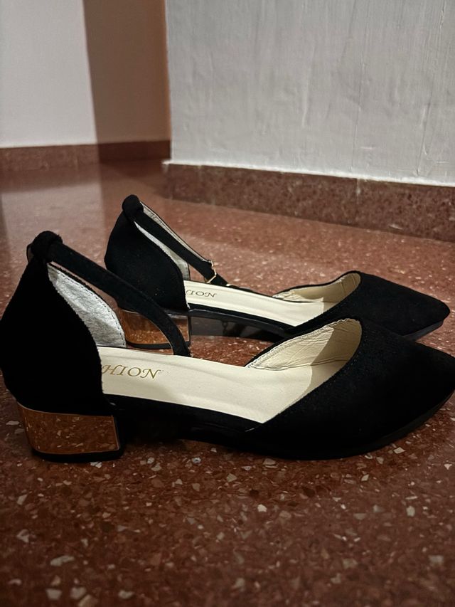 Zapatos negros con detalle dorado
