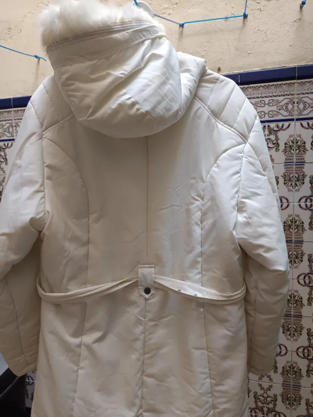 Chaqueta plumífero blanco con capucha.