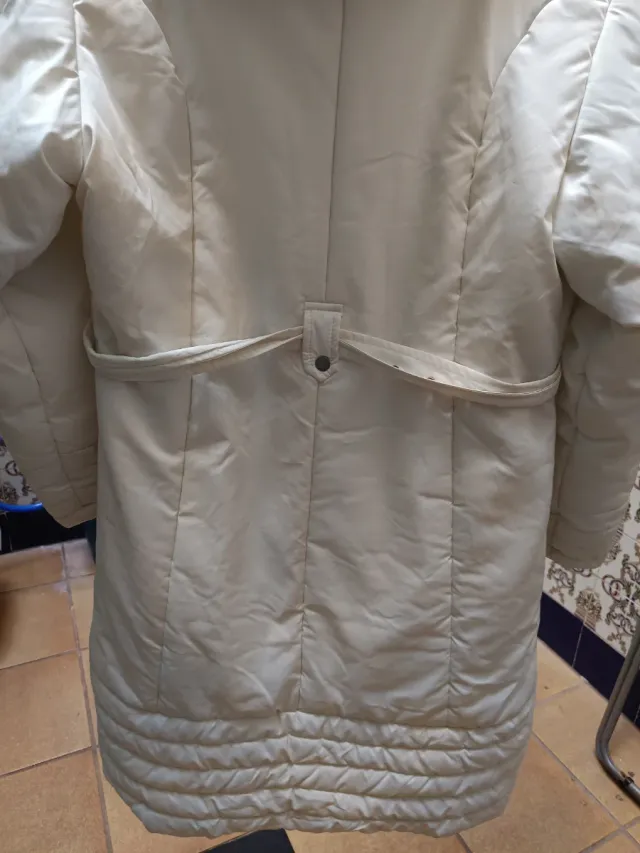 Chaqueta plumífero blanco con capucha.