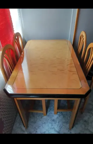 Mesa de comedor extensible con tapa de cristal.