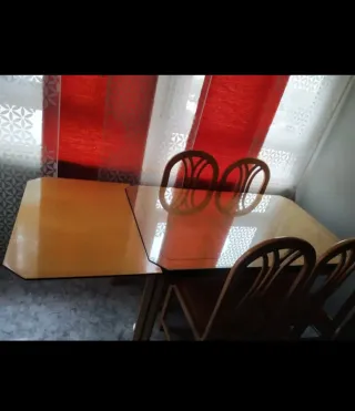 Mesa de comedor extensible con tapa de cristal.