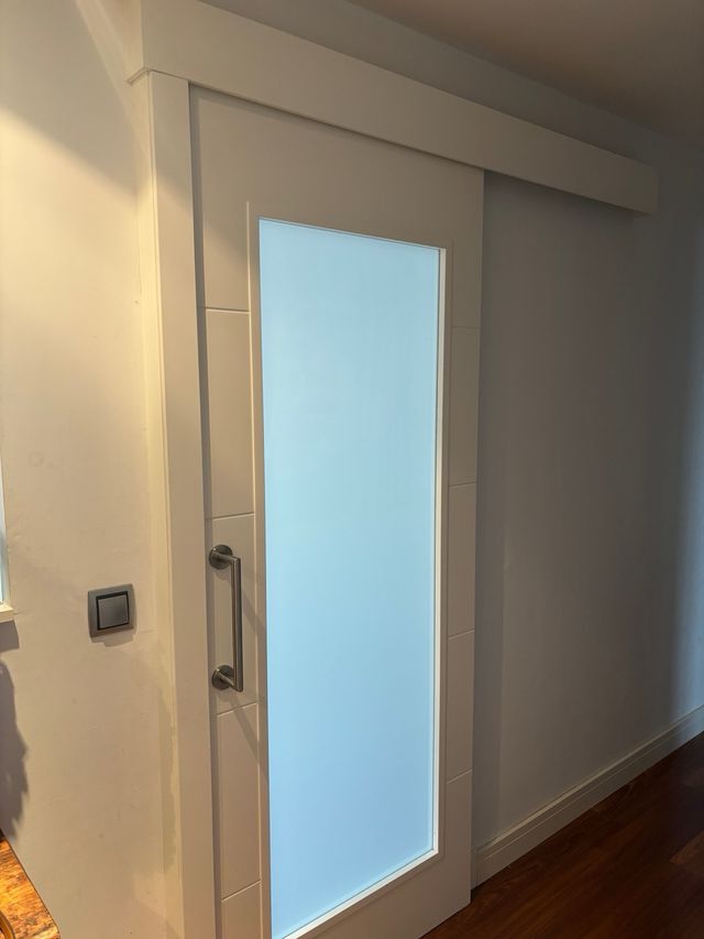 Puerta corredera blanca con cristal