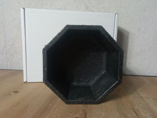 Pezzo ottagonale in cemento di colore granito.