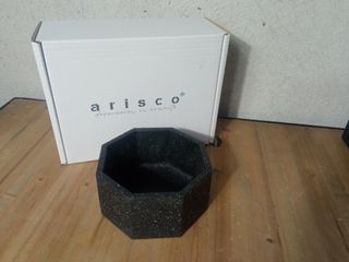 Pezzo ottagonale in cemento di colore granito.