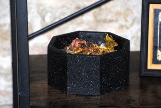 Pezzo ottagonale in cemento di colore granito.