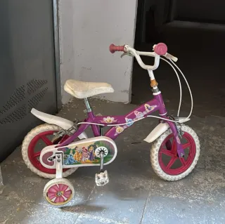 Bicicleta infantil morada con ruedas de apoyo