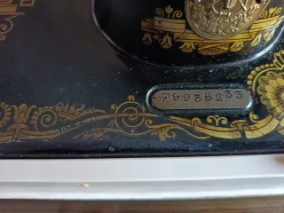 Máquina de coser Singer antigua, con motor y libro