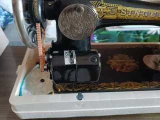 Máquina de coser Singer antigua, con motor y libro