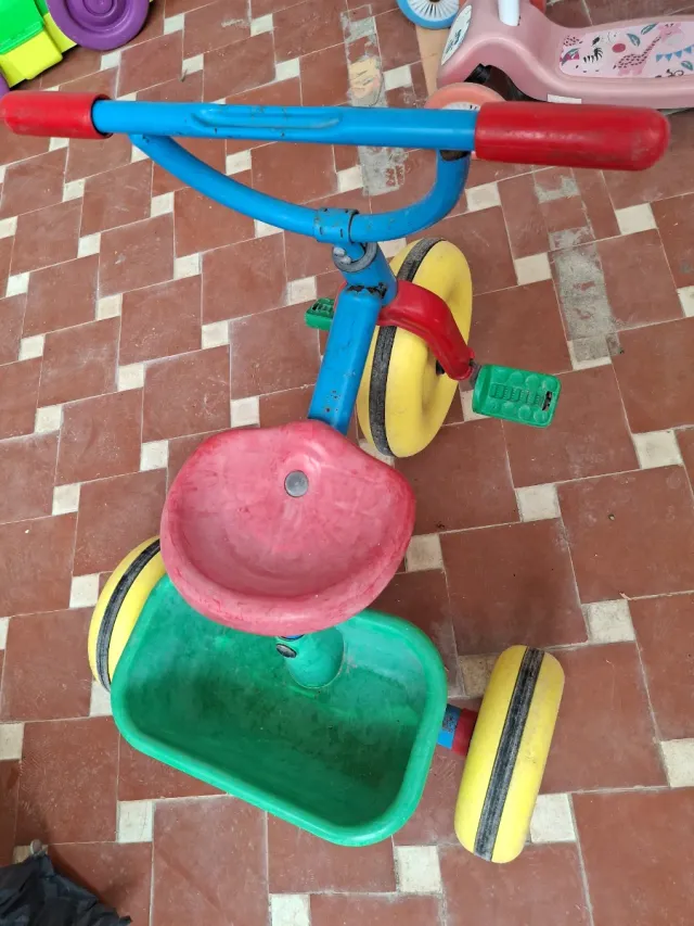 Triciclo infantil rojo, azul y amarillo