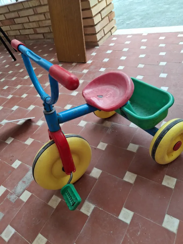 Triciclo infantil rojo, azul y amarillo