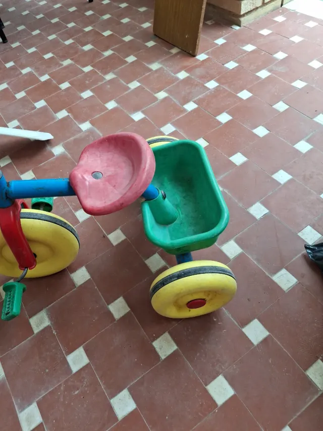Triciclo infantil rojo, azul y amarillo