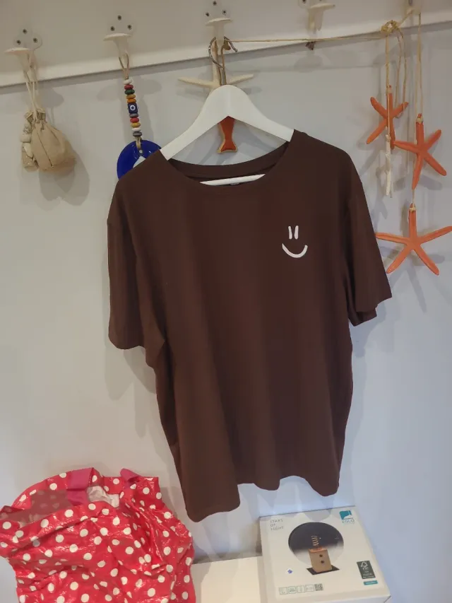 Camiseta marrón con cara sonriente