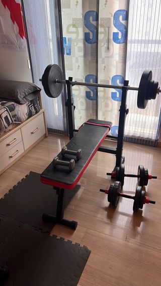 Banco de pesas con mancuernas y barra