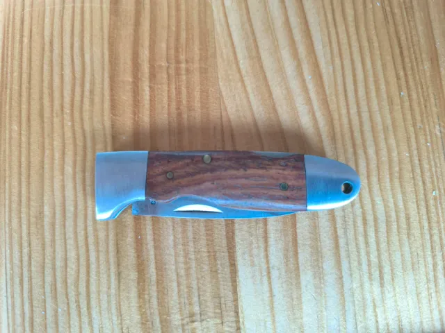 Strumento in acciaio con manico in legno. Lama