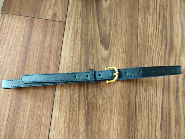 Cinturón negro con hebilla dorada