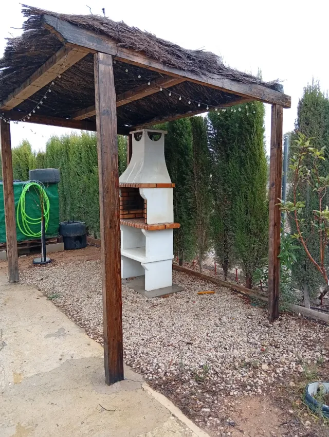 Barbacoa de ladrillo y hormigón con pérgola
