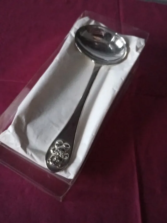 Cuchara de plata para bebé con osito en el mango.