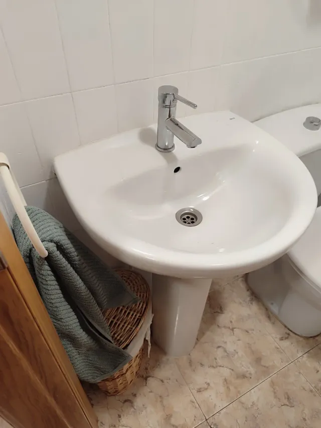 Lavabo de cerámica con pedestal. Grifo nuevo