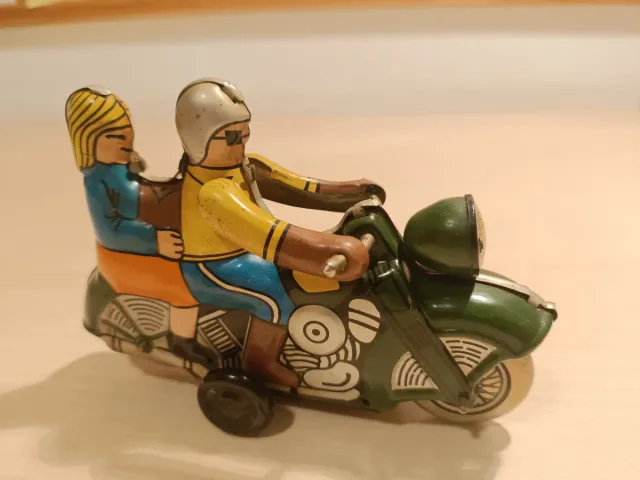 Moto de hojalata antigua con figuras