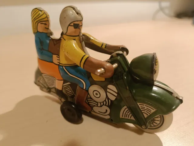 Moto de hojalata antigua con figuras