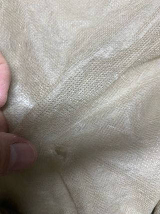 Bolso color caqui con asas de piel blancas.