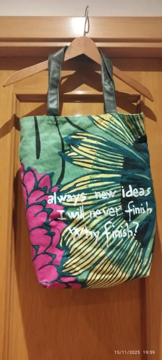 Bolso de hombro con flores y texto.