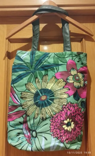 Bolso de hombro con flores y texto.