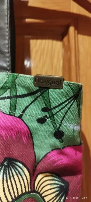 Bolso de hombro con flores y texto.