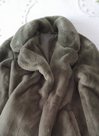 Pelliccia verde oliva con tasche laterali.