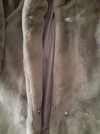 Pelliccia verde oliva con tasche laterali.