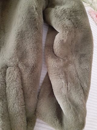 Pelliccia verde oliva con tasche laterali.