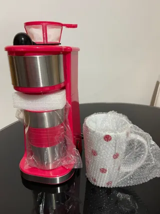 Cafetera individual con taza y termo.