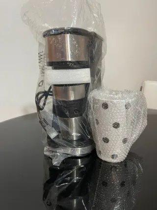 Cafetera individual con taza y termo.