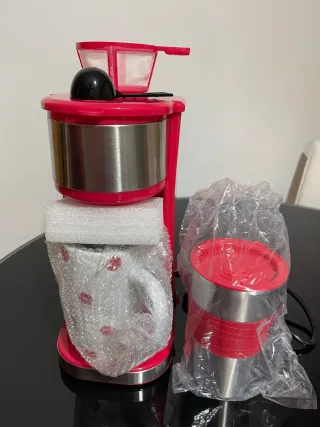 Cafetera individual con taza y termo.