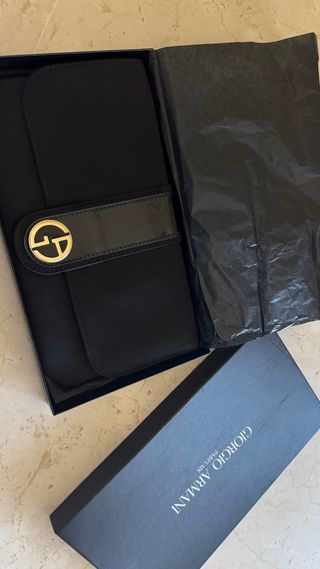 Bolso de mano Armani negro y dorado.