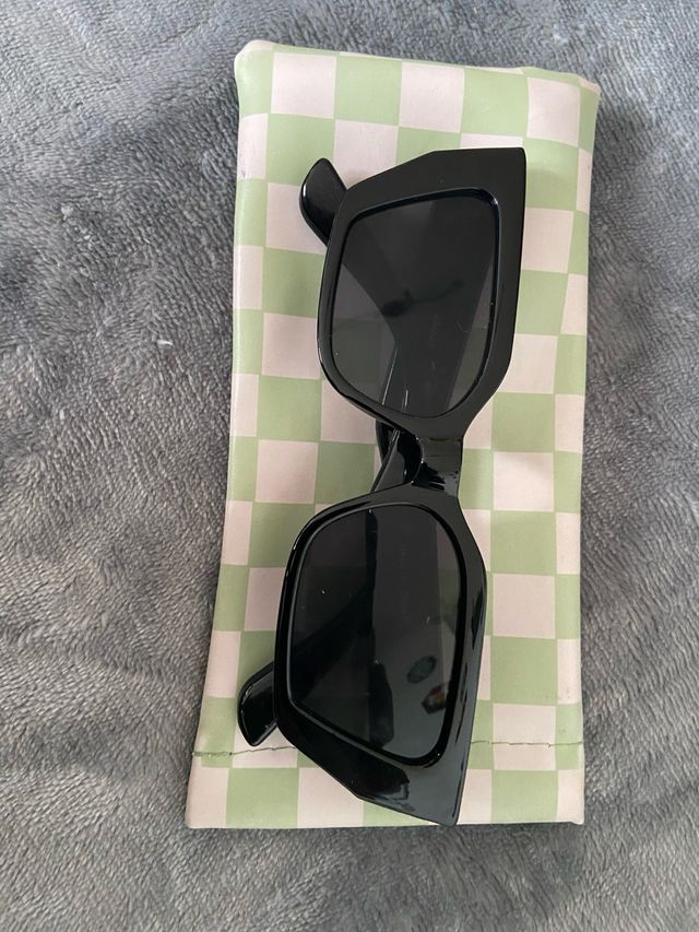 Gafas de sol negras cuadradas junto funda