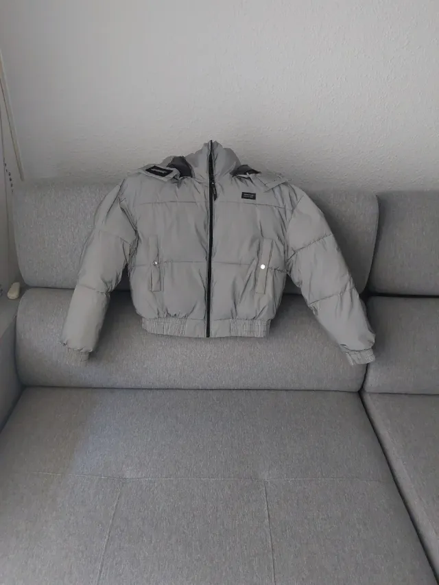 Cazadora acolchada gris, con capucha, calentita.