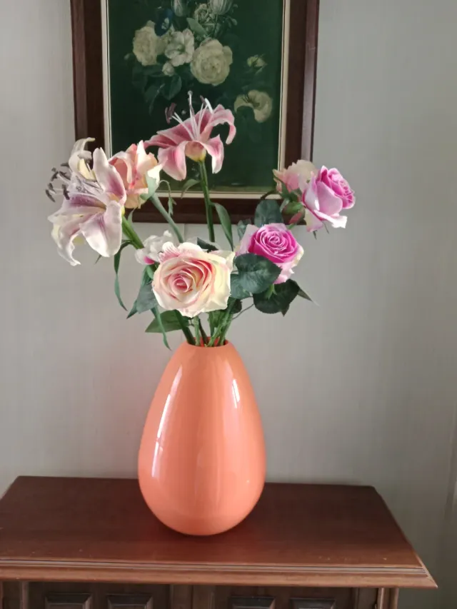 Jarrón naranja con flores artificiales