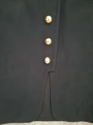 Falda azul marino con botones dorados.