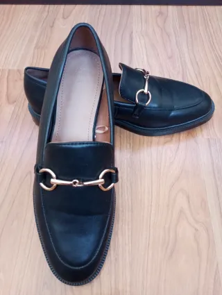 Zapatos negros con detalle dorado